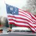 John Ochs, of Ann Arbor, holds a flag as he waits for Republican presidential candidate Herman Cain to arrive at the Big Sky Diner in Ypsilanti during a stop on Thursday morning. Melanie Maxwell I AnnArbor.com